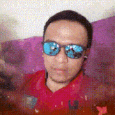 a man wearing sunglasses and a red shirt is laying on a purple couch