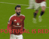 a soccer player celebrates a goal with the words portugal is red in red letters