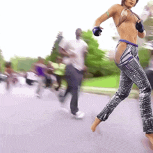 a woman without a shirt is walking down the street
