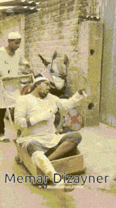 a man is sitting in a box with the words memar dizayner on the bottom right