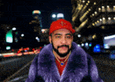 a man wearing a fur coat and a red hat with a fleur de lis on it