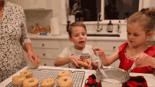 a boy wearing a shirt that says super mario is making donuts