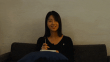 a woman sitting on a couch holding a lollipop in her hand