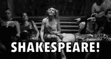 a group of people sitting around a man laying on the ground with the words shakespeare written above them