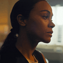 a close up of a woman 's face with a ponytail and earrings