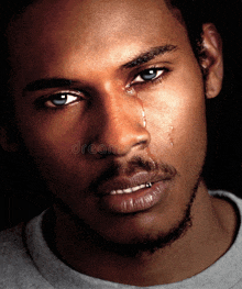 a man with blue eyes is crying with tears running down his face