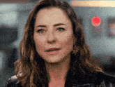 a close up of a woman 's face with a red light behind her