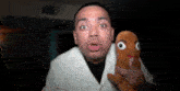 a man in a white coat is holding a stuffed animal in his hands .