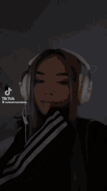 a woman wearing headphones has a tiktok icon on her face