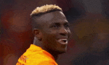 a soccer player is smiling and holding a camera in his hand