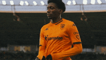 a soccer player wearing an orange shirt that says corendon