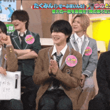 a group of young men are sitting in a room and one of them has a name tag that says etsuya