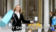 a woman is holding shopping bags and says `` happy shopping my love '' while walking down the street .