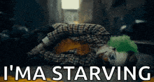 a clown is laying on the ground with the words `` i 'm a starving '' written above him .