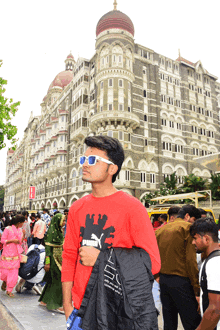 a man in a red puma shirt stands in front of a building