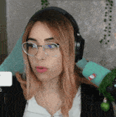 a woman wearing glasses and headphones has a christmas ornament on her shoulder