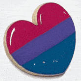 a heart shaped cookie is being decorated with purple and blue frosting