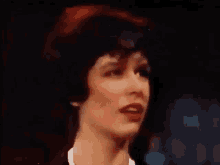 a close up of a woman 's face in a dark room