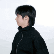 a man wearing a black jacket with a zipper on the side