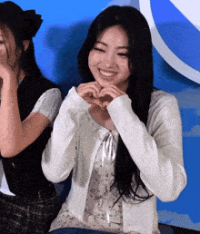 a woman making a heart shape with her hands and smiling