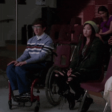 a man in a wheelchair sits next to a woman