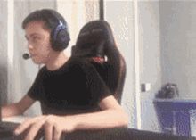 a young man wearing headphones and a headset is sitting in a chair playing a video game .
