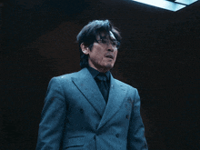 a man in a suit and tie is standing in the dark