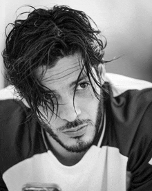 a black and white photo of a man with a beard and long hair .