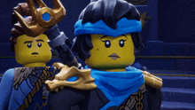 two lego characters are standing next to each other and one has a crown on her head