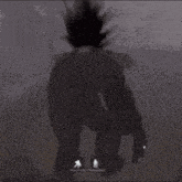 a silhouette of a person standing in the dark with a blurred background .