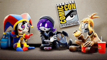 a group of cartoon characters sitting in front of a comic con sign