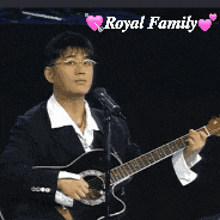 a man is singing into a microphone while holding a guitar in front of a royal family logo