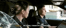 a man and a woman in a police car with the woman saying lucy