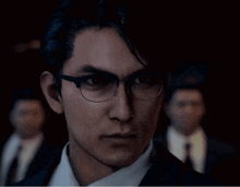 a man wearing glasses and a suit looks serious