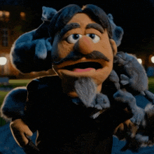 a puppet with a beard and mustache holds a squirrel