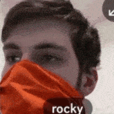 a man with a beard is wearing a red mask on his face .