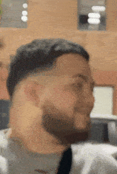 a man with a beard is making a funny face while looking at the camera .