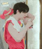 a man in a red shirt is holding a can of soda and the word code is on the bottom right