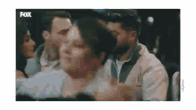 a man and woman are kissing in a crowd of people .
