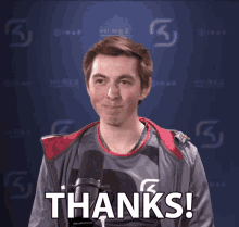 a man stands in front of a microphone with the words thanks on the bottom