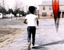 a man in a white shirt and black pants is walking down a street