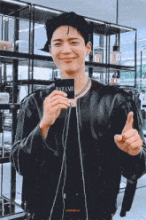 a man in a leather jacket holds a card that says bazaar