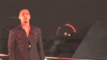 a man in a black shirt is standing in front of a sign that says " the maw "