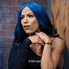 a woman with blue hair is sitting in a chair and says it felt real