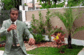 a man in a suit and tie is standing in front of a brick wall