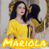 a woman in a yellow dress is standing in front of a mirror and the name mariola is on the bottom