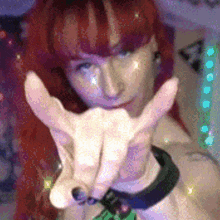 a woman with red hair making a peace sign with her hands