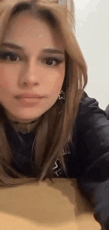 a close up of a woman taking a selfie while laying down on a table .