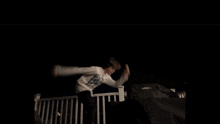 a person wearing headphones is standing on a balcony at night