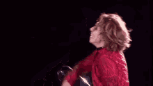 a shirtless man in a red shirt is dancing on a stage .